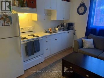 London East (East E) multi-family for rent - A kitchen with white cabinets and a refrigerator.