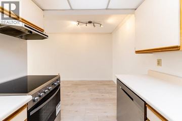 Vancouver apartment for rent - A kitchen with a black stove top oven and white countertops.