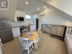 Vancouver house for rent - A modern kitchen with a dining table and chairs.