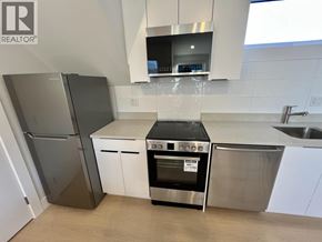 Vancouver house for rent - A modern kitchen with a stainless steel refrigerator, oven, and microwave.
