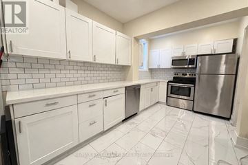 Hamilton (Kirkendall) duplex for rent - A kitchen with white cabinets and a stainless steel refrigerator.