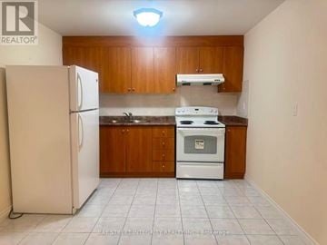 Markham (Wismer) house for rent - A kitchen with white appliances and wooden cabinets.