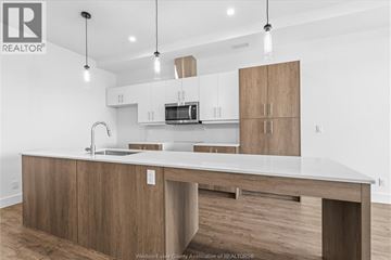 Windsor condo for rent - A bedroom with a large bed, two nightstands, and a dresser.