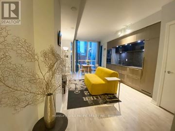 Toronto (Waterfront Communities) condo for rent - A modern living room with a yellow chair and a large window.