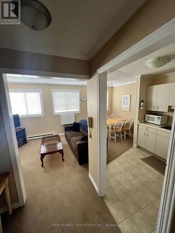 Cambridge other for rent - A living room with a couch, a coffee table, and a dining area with a table and chairs.