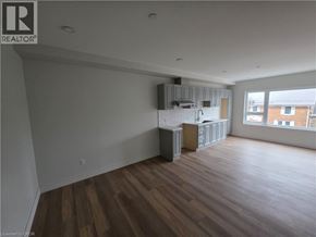 Woodstock apartment for rent - A large empty room with wooden floors and a kitchenette in the corner.