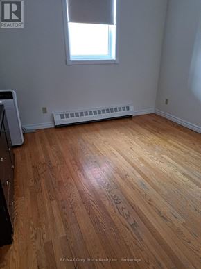 Meaford condo for rent - A room with a wooden floor and a window.