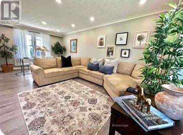 Oakville (Wo West) house for rent - A living room with a beige sofa and a rug.