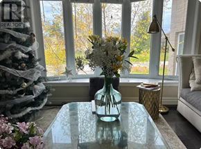 Oakville (Wo West) house for rent - A glass vase with flowers sits on a table in front of a Christmas tree.