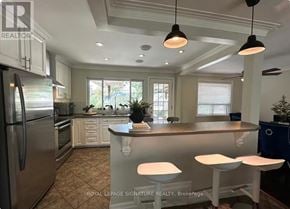 Oakville (Wo West) house for rent - A kitchen with a refrigerator, bar stools, and pendant lights.