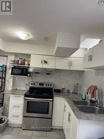 Brampton (Credit Valley) house for rent - A kitchen with white cabinets and a stove top oven.
