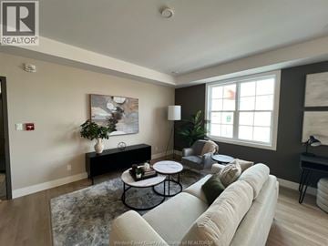 Windsor apartment for rent - A living room with a couch, coffee table, and a painting on the wall.