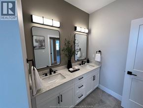 Windsor apartment for rent - A bathroom with a sink, mirror, and lighting fixtures.