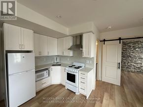 North Grenville multi-family for rent - A modern kitchen with white appliances and cabinets.