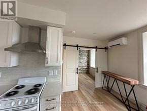 North Grenville multi-family for rent - A kitchen with a stove top oven and a range hood.
