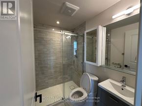 North Grenville multi-family for rent - A bathroom with a toilet, sink, and glass shower stall.