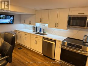 Toronto (Bathurst Manor) house for rent - A kitchen with white cabinets and a stainless steel refrigerator.