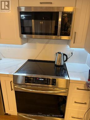 Toronto (Bathurst Manor) house for rent - A kitchen with a stove top oven and microwave.