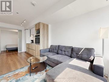 Toronto (Church-Yonge Corridor) condo for rent - A living room with a grey couch and a round table in the middle.