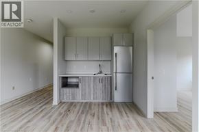 Brantford apartment for rent - A kitchen with white cabinets and a refrigerator.