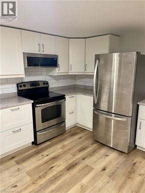 Hamilton house for rent - A kitchen with a stainless steel refrigerator and oven.