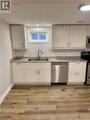 Hamilton house for rent - A kitchen with white cabinets and a wooden floor.