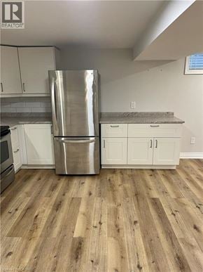 Hamilton house for rent - A kitchen with a stainless steel refrigerator and wooden floors.