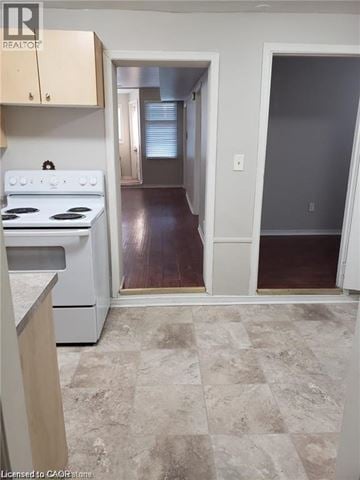 Hamilton house for rent - A kitchen with a white stove top oven and a tiled floor.