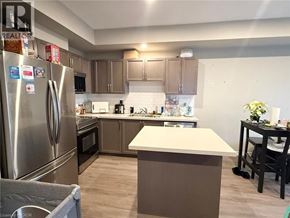 Welland townhouse for rent - A kitchen with a refrigerator, oven, and countertop.
