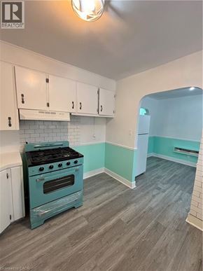 St. Catharines house for rent - A kitchen with a blue stove and white cabinets.