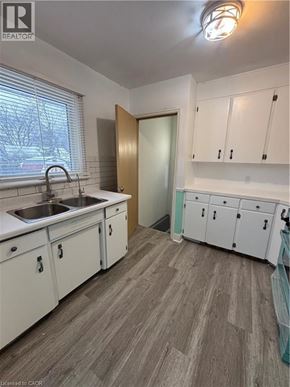 St. Catharines house for rent - A kitchen with white cabinets and a sink.