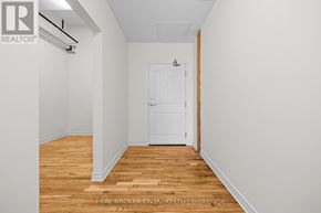 Carleton Place multi-family for rent - A white door is in the middle of a room with wood floors and white walls.