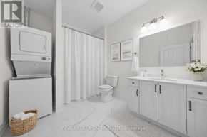Carleton Place multi-family for rent - A white bathroom with a toilet, sink, and shower curtain.