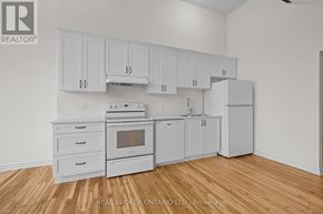 Carleton Place multi-family for rent - A kitchen with white cabinets and appliances on a wood floor.