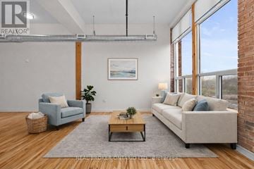 Carleton Place multi-family for rent - A living room with a blue couch, a grey rug, a wooden coffee table, and a painting on the wall.