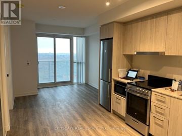 Vaughan (Vaughan Corporate Centre) condo for rent - A kitchen with wooden cabinets and a stainless steel refrigerator.