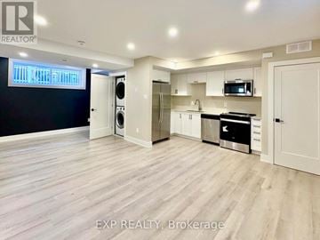 Ottawa house for rent - A spacious kitchen with white cabinets and a black countertop.