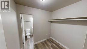 For rent in Grande Prairie - A white bathroom with a toilet and a shelf.