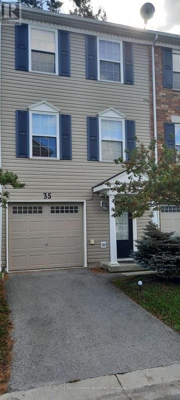 Barrie (Holly) townhouse for rent - A two-story building with a garage and a driveway in front.