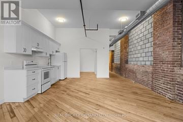 Carleton Place multi-family for rent - A kitchen with white cabinets and a wooden floor.