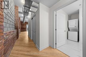 Carleton Place multi-family for rent - A hallway with a brick wall on the left and a white door on the right.
