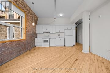 Carleton Place multi-family for rent - A kitchen with white cabinets and a brick wall.