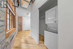 Carleton Place multi-family for rent - A kitchen with a white fridge and a brick wall.