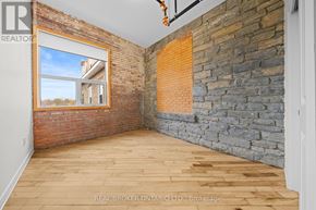 Carleton Place multi-family for rent - A room with wooden floors and a brick wall.
