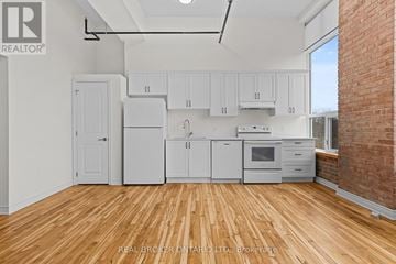 Carleton Place multi-family for rent - A kitchen with white cabinets and wooden floors.