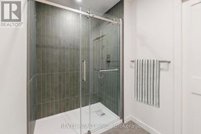 Lincoln (Beamsville) multi-family for rent - A bathroom with a glass shower door and a white wall.