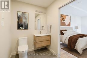 Lincoln (Beamsville) multi-family for rent - A bathroom with a toilet, sink, and mirror.