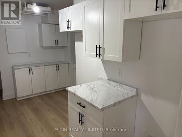 London South (South F) multi-family for rent - A kitchen with white cabinets and a marble island.