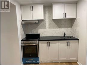 Vaughan (Vellore Village) house for rent - A kitchen with white cabinets and a black countertop.