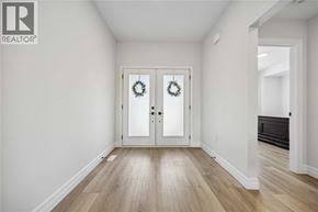 Sarnia house for rent - A white hallway with a wooden floor and a door with a wreath on it.